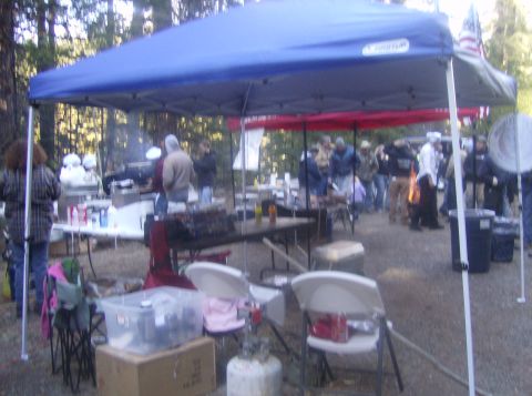 1986 Ford Bronco - An outdoor event with people mingling under tents, with food and drinks set up on tables.