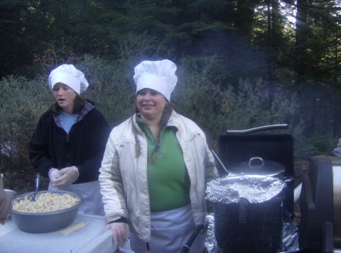 1986 Ford Bronco - Two individuals in chef hats are seen preparing food at an outdoor event, with a grill visible in the background.