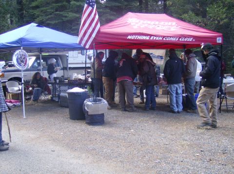 1986 Ford Bronco - A white Ford Bronco is parked under a blue canopy at an outdoor gathering.