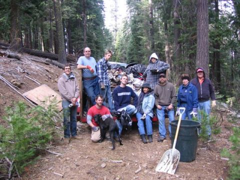 1989 Ford Bronco - People gathered in a forest with trash and a shovel, possibly after a cleanup event.