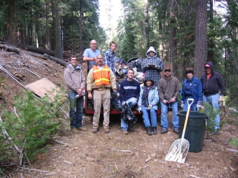 1989 Ford Bronco - A group of volunteers gathered in a wooded area to clean up litter and debris.