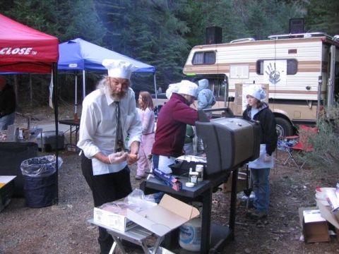 1989 Ford Bronco - An RV is parked at an outdoor event where people are gathered around a grill.