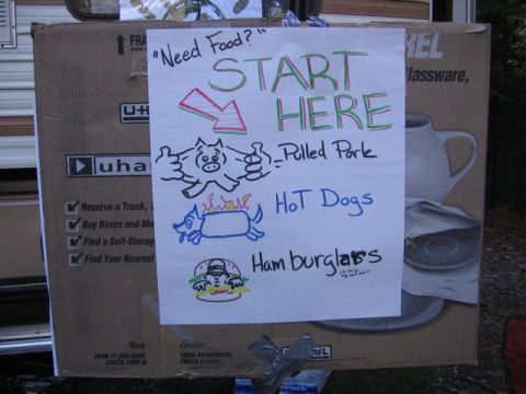 1989 Ford Bronco - A sign indicates food options including pulled pork, hot dogs, and hamburgers, with cartoon drawings of food items.