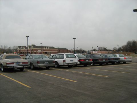 1988 Mercury Grand Marquis - Several cars are parked in a lot under an overcast sky.