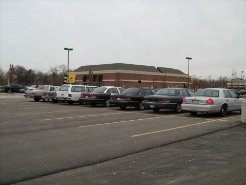 1988 Mercury Grand Marquis - A silver sedan is parked in a lot alongside several other vehicles, including black sedans and white vans.