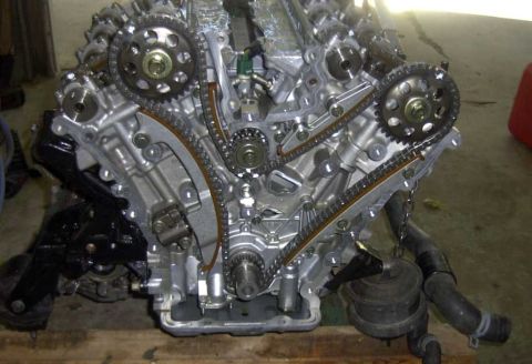 1997 Ford Taurus - Front of a disassembled overhead-cam V6 engine block exposing the timing chains, gears and sprockets.
