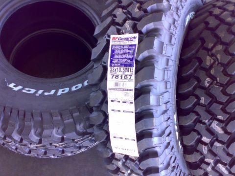 1995 Ford F-150 - Two new BF Goodrich Mud-Terrain T/A KM tires stacked/leaning, with a paper spec label reading size 33x10.50R15, RWL/LBR, LRC, item 78167.