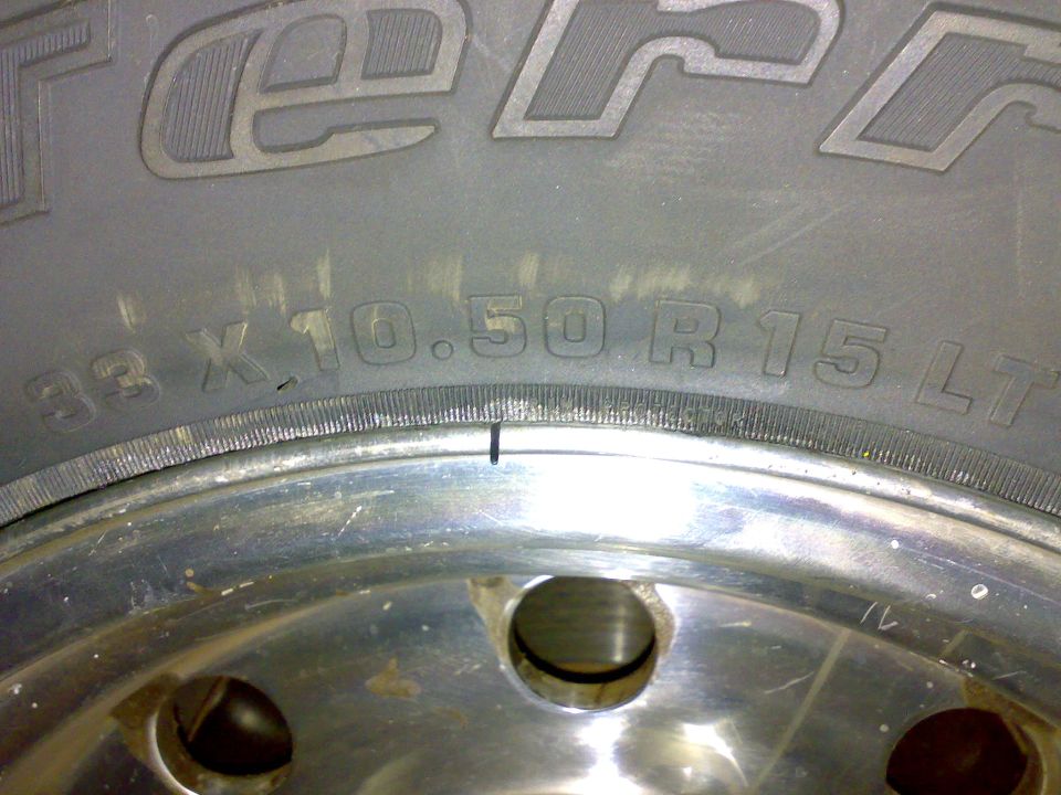 Tire sidewall marked 33x10.50R15 LT on a polished aluminum wheel