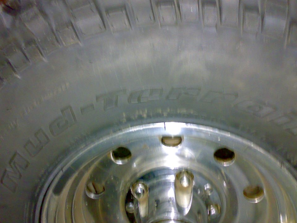 Mud-Terrain tire sidewall and tread on a polished aluminum wheel, close-up