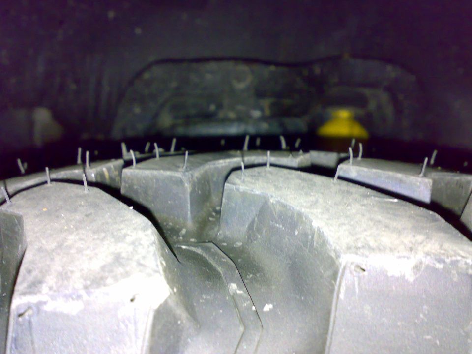 Close-up of new mud-terrain tire tread blocks with molding nubs still attached