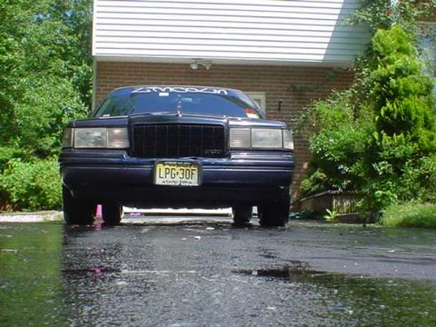1994 Lincoln Town Car - Front view of a 1994 Lincoln Town Car parked outside a house on a wet day.