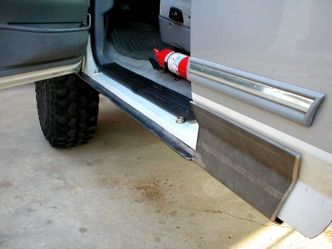 1996 Ford Bronco - Interior view of a 1996 Ford Bronco, an open door and a fire extinguisher. A custom rocker panel is visible.