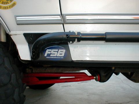 1996 Ford Bronco - Close-up of the side of a Ford Bronco, showing aftermarket steps and suspension parts.