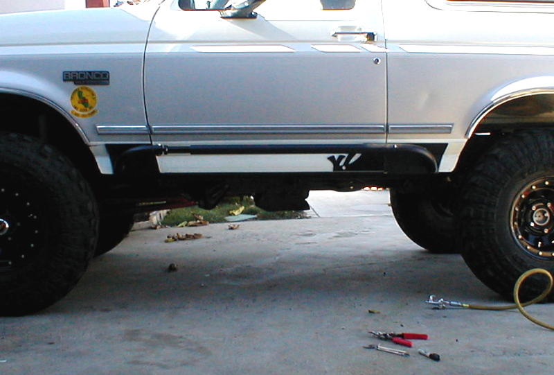White 1996 Ford Bronco side view, showing the door, fender, and large tires