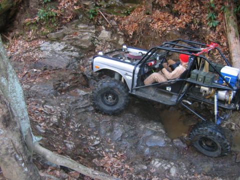 1992 Ford Mustang - Custom Bronco navigating a difficult off-road trail with large tires and roll cage.