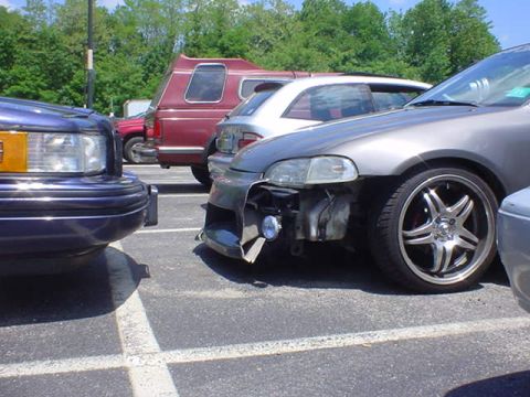 1994 Lincoln Town Car - A dark blue Lincoln Town Car is parked in a lot next to other vehicles.