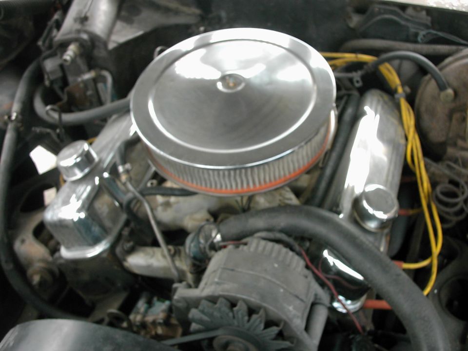 V8 engine bay with chrome air cleaner, chrome valve covers, alternator, and yellow plug wires