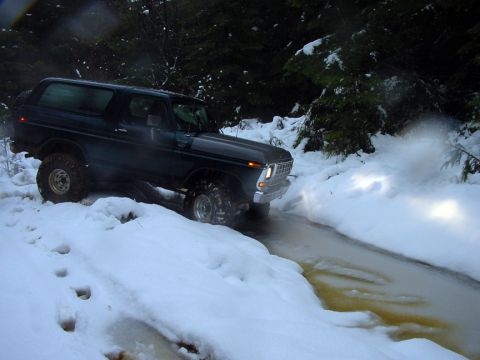 1979 Ford Bronco - 1978 Ford Bronco navigates a snowy, icy trail in a wooded area.