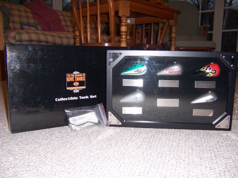 1987 Ford Bronco - A collection of miniature motorcycle fuel tanks are displayed in a case next to their packaging.