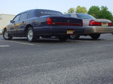 1994 Lincoln Town Car - A 1994 Lincoln Town Car is seen from the rear, parked next to another sedan.