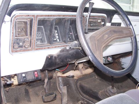 1979 Ford Bronco - The interior of a 1979 Ford Bronco shows its dashboard, steering wheel, and floor pedals.