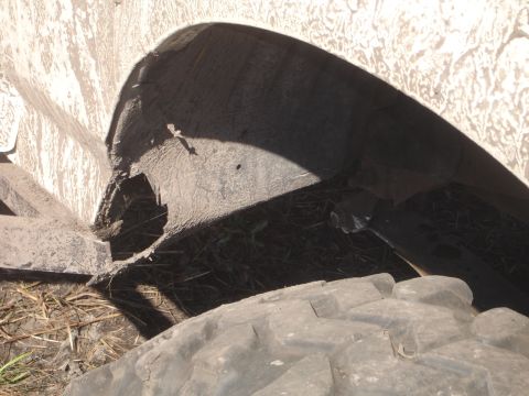 1989 Ford Bronco - Close-up view of a damaged wheel well and tire, covered in mud.