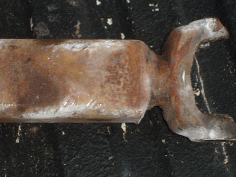 1989 Ford Bronco - A close-up view of a heavily rusted metal component, possibly a driveshaft yoke or similar automotive part.