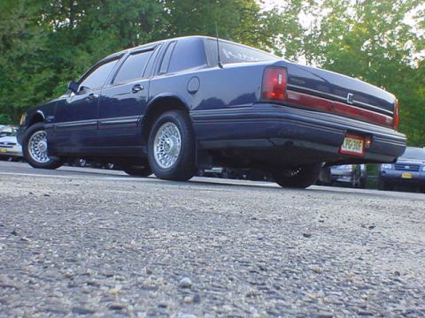 1994 Lincoln Town Car - The rear of a 1994 Lincoln Town Car is visible, with a license plate that reads PG30F.