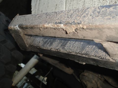 1989 Ford Bronco - The underside of a vehicle is shown, with visible dirt and wear on its components.