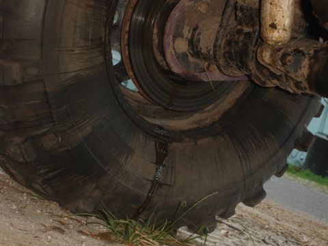 1989 Ford Bronco - A close-up view of a vehicle's wheel assembly, showing a large tire and suspension components with visible fluid leakage.