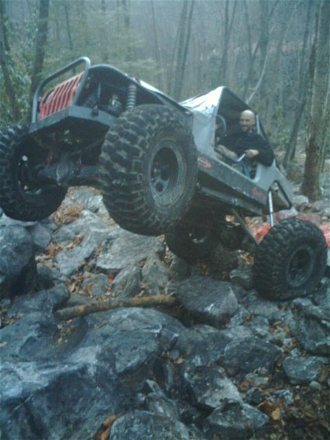 1992 Ford Mustang - A custom off-road buggy navigates a rocky trail with one wheel in the air.
