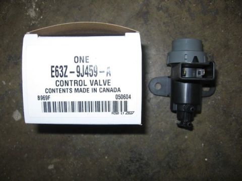 1989 Ford Bronco - A new Ford control valve, part number E63Z-9J459-A, laid on a concrete floor beside its white cardboard box printed "ONE E63Z-9J459-A CONTR…
