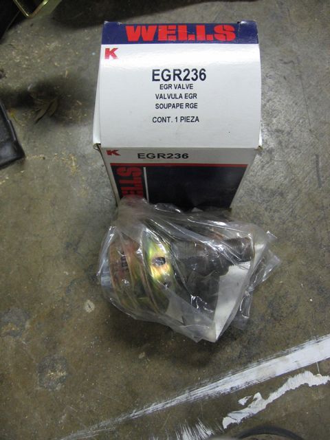 1989 Ford Bronco - EGR valve part in packaging on a concrete surface.
