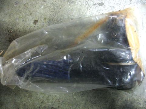 1989 Ford Bronco - Unidentified automotive part in plastic packaging on a concrete floor.