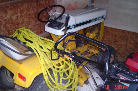 1946 Ford F1 - Cub Cadet 108 tractor with a large coil of yellow rope draped over the seat and frame.