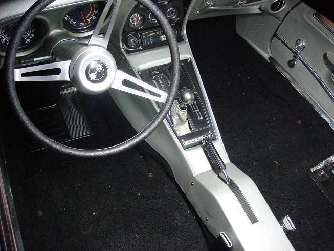 Interior of a Chevrolet Corvette showing steering wheel, gauges and shifter console