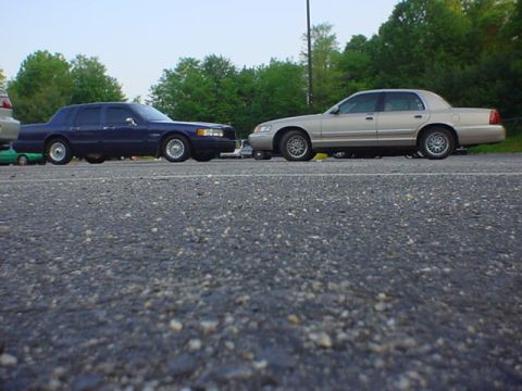 1994 Lincoln Town Car - Two sedans, including a 1994 Lincoln Town Car, are parked next to each other on a paved surface.
