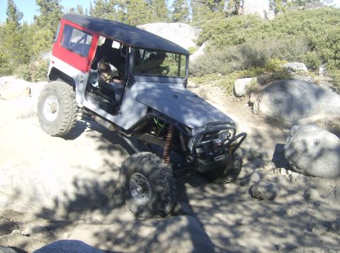 1986 Ford Bronco - This heavily modified off-road vehicle is shown traversing a challenging rocky landscape.