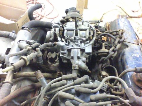 1979 Ford Ranchero - Close-up view of an engine assembly, likely out of a vehicle, showing the carburetor and associated components.