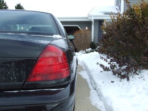 2003 Ford Crown Victoria - Rear view of a black 2003 Ford Crown Victoria parked in a snowy driveway.
