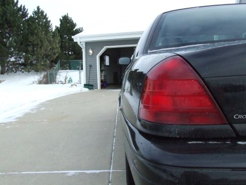 2003 Ford Crown Victoria - Rear quarter view of a black 2003 Ford Crown Victoria parked in a driveway during winter.