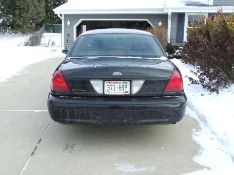 2003 Ford Crown Victoria - Rear view of a black 2003 Ford Crown Victoria parked in a snowy driveway.