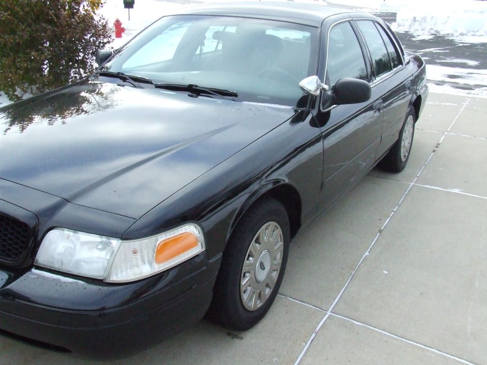 Black 2003 Ford Crown Victoria parked on a concrete driveway