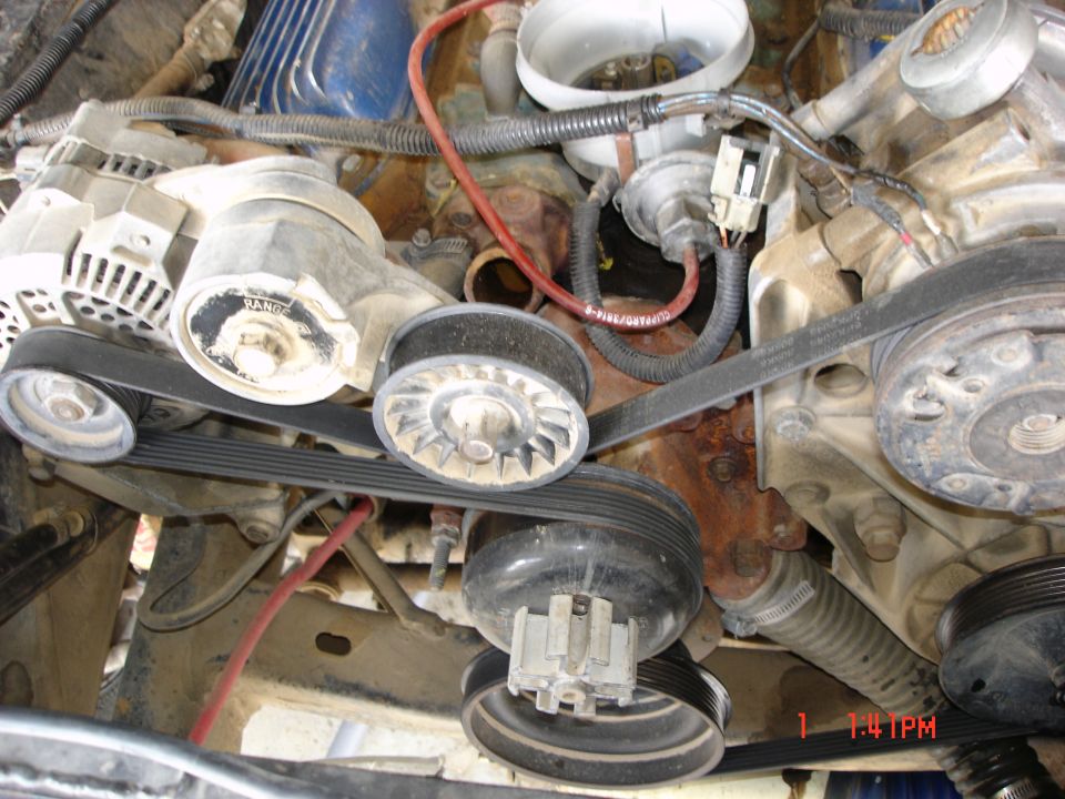 Engine bay showing serpentine belt system, alternator, and pulleys