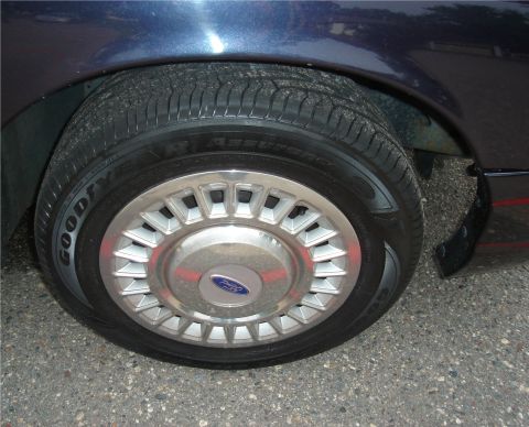 1999 Ford Crown Victoria - Close-up of a car's wheel and tire, showing the tread and hubcap details.