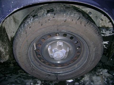 1999 Ford Crown Victoria - A close-up view of a car's wheel and tire, a Ford logo on the hubcap.