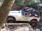 1992 Ford Mustang - This off-road vehicle navigates a challenging trail through a wooded area, displaying the number 53 on its side.