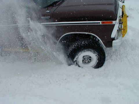 1979 Ford Bronco - A 1978 Ford Bronco navigates through a snowy landscape, its tires churning up a significant amount of snow.
