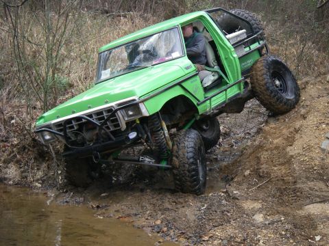 1978 Ford Bronco - This modified 1978 Ford Bronco navigates a challenging muddy incline during an off-road excursion.