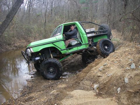 1978 Ford Bronco - Off-road truck navigates challenging terrain with water and mud obstacles.